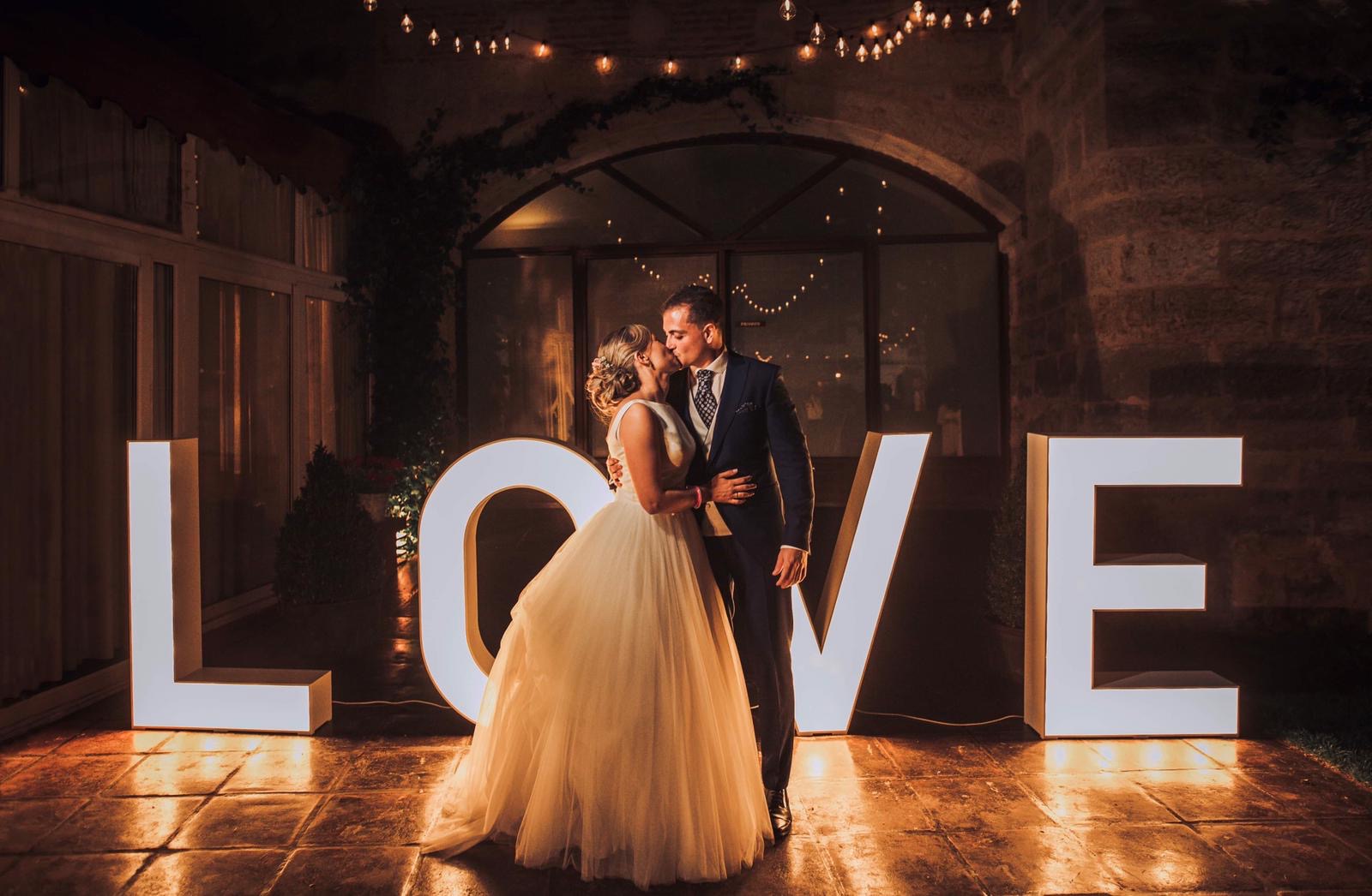 Letras LOVE iluminadas en un jardín